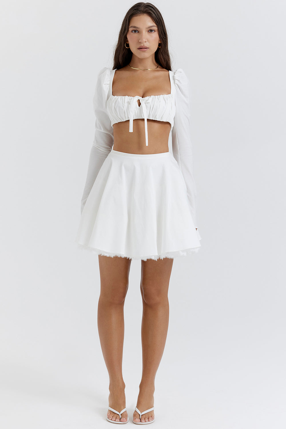 White top with puff sleeves and mini skirt with bow